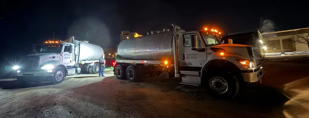Two AWR tankers at night with headlights and amber beacons lit